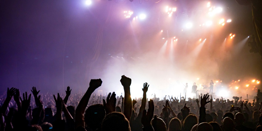 Image of a concert going on and crowd cheering up in a Music festival