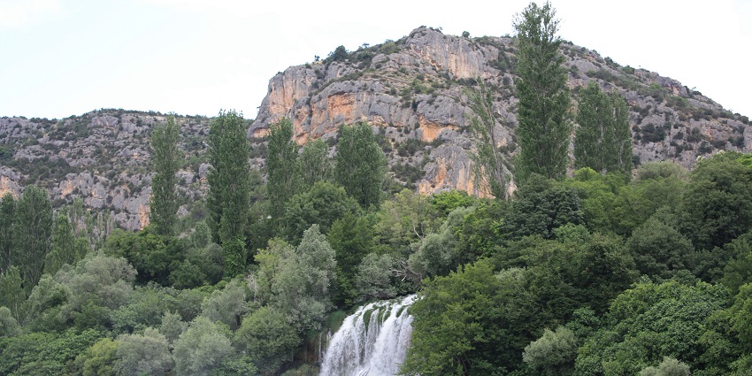 A picture of beautiful waterfalls of Croatia with the high mountain ranges all over surrounding it.