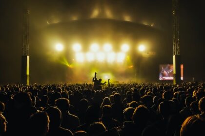 A DJ performs live on stage with a vibrant crowd at the 2009 Sun God Festival in California.