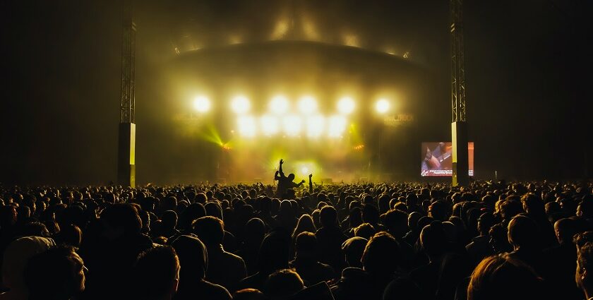 A DJ performs live on stage with a vibrant crowd at the 2009 Sun God Festival in California.