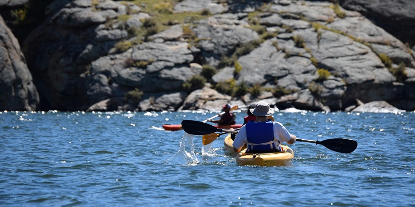 An image of people kayaking in the waters of the San Juan Islands, a popular kayaking spot in the USA.