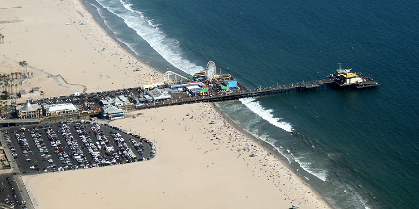An aerial view of Santa Monica Pier, a famous place near the Getty Museum, showing the beach.