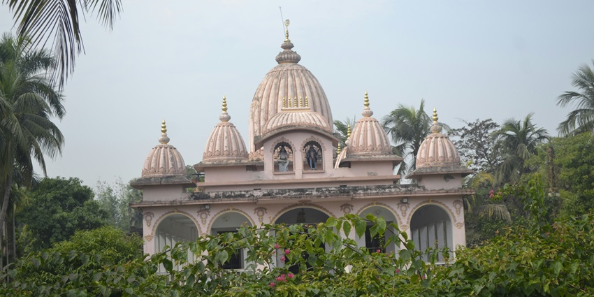 A frontal view of a traditional ashram in Haridwar, surrounded by greenery