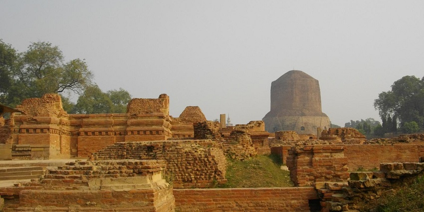 View of ruins with a big stupa in the background in Sarnath, suggested by Varanasi Travel Guide.
