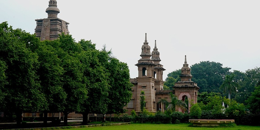 Distant view of a Buddhist temple at Sarnath, Varanasi, India, amidst greenery.
