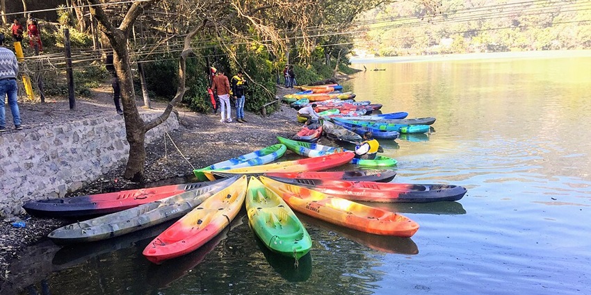 Image of Sattal lake in Nainital district Uttrakhand surrounded by lush greenery and small boats for rides