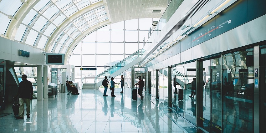 An Interior view of an airport building with seating and large glass windows.