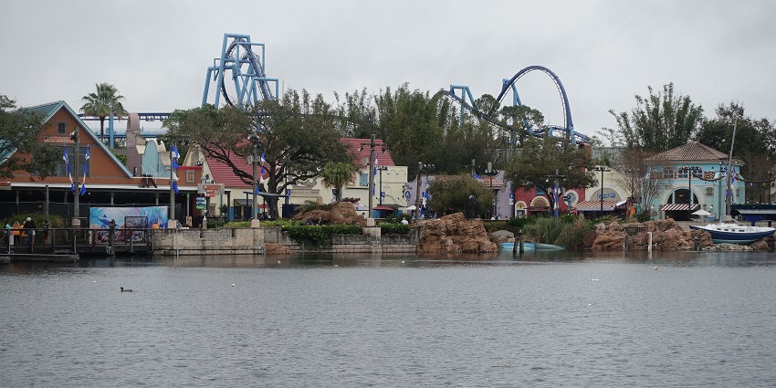SeaWorld Orlando from a small lake with roller coaster rides visible with other attractions.