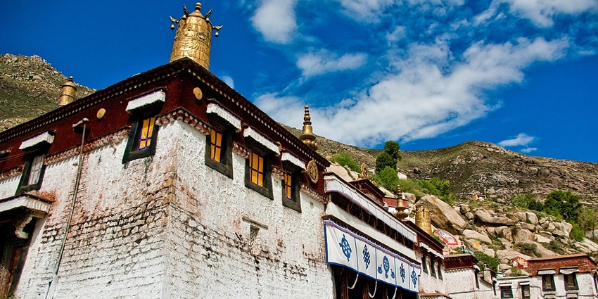White-washed buildings, golden roofs and stupa of Sera Monastery.