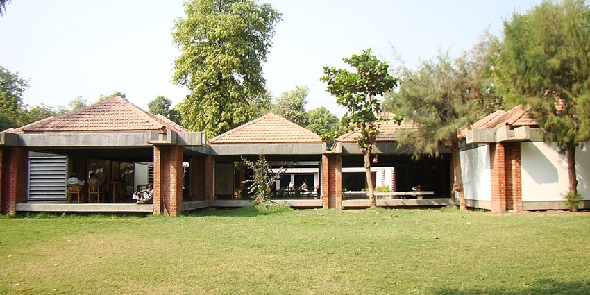 Image of an Ashram surrounded by lush greenery during day time view