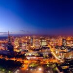 Nairobi city skyline at night with illuminated tall skyscrapers and roads under blue sky