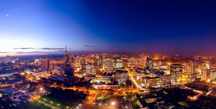 Nairobi city skyline at night with illuminated tall skyscrapers and roads under blue sky