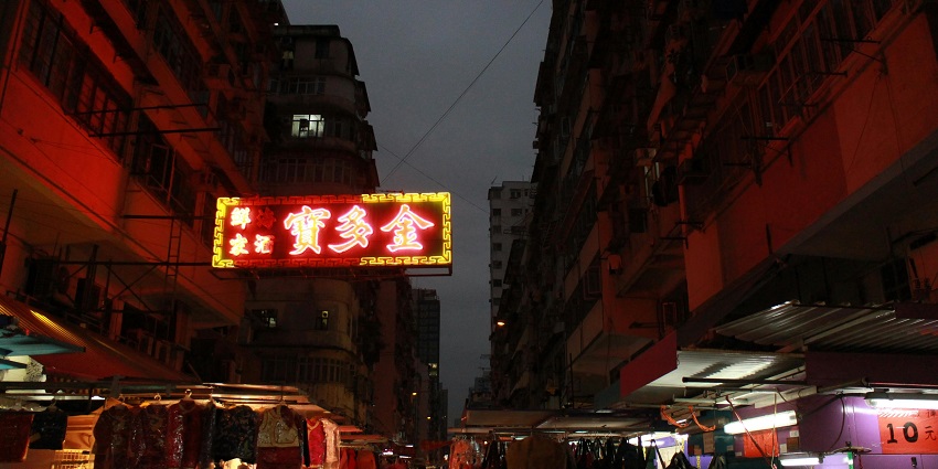 Image of a night market in China with vibrant lights and display hanging