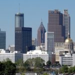 A view of the Skyline of Atlanta at dusk, showcasing tall buildings and city lights under a vibrant sky.