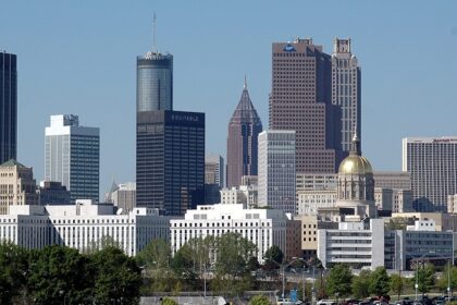 A view of the Skyline of Atlanta at dusk, showcasing tall buildings and city lights under a vibrant sky.