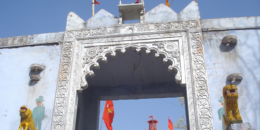 A priest sprinkling holy water from Puja Thali at Shri Sheetla Devi Temple in Haryana