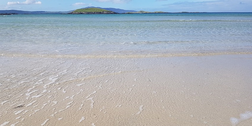An image of Silver Strand in County Donegal, showing its quiet beach and clear water