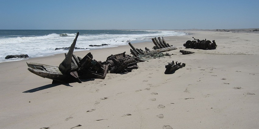 Shipwreck of the Southwest Seal at the Skeleton Coast in Namibia with blue waters and sand