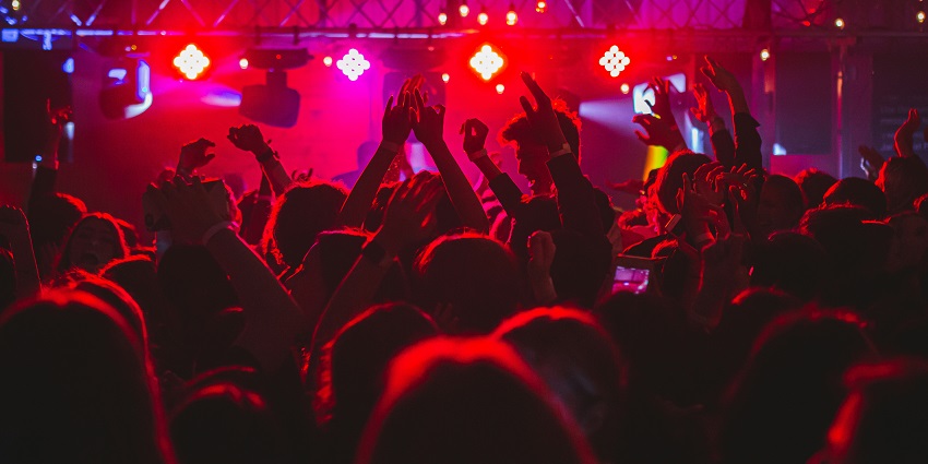 A scene in a club where some people are on stage, some are dancing below.