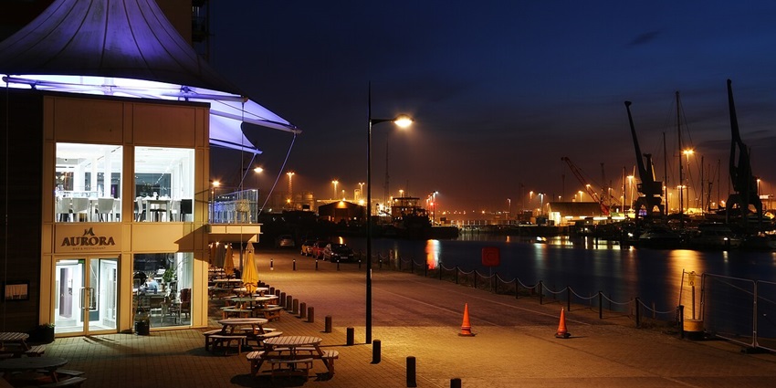 Waterfront with street lamps, cones and small benches with chairs, displaying Dar es salaam nightlife.