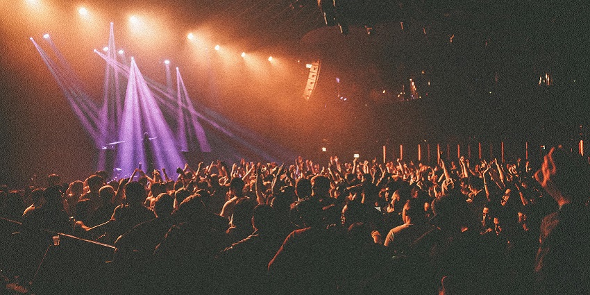 People enjoying a concert with bright stage lights at a New Year party in New York.