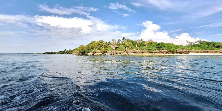 Watamu Marine National Park is featuring huts and lush greenery on an island in the sea.