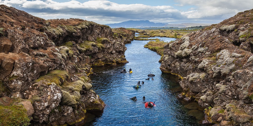 An image of a boy diving in the waters resembling Silfra, a famous place to visit in Iceland
