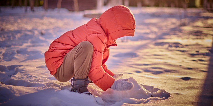 Image of a snow inside snow world - Side View of a Child Playing with Snow