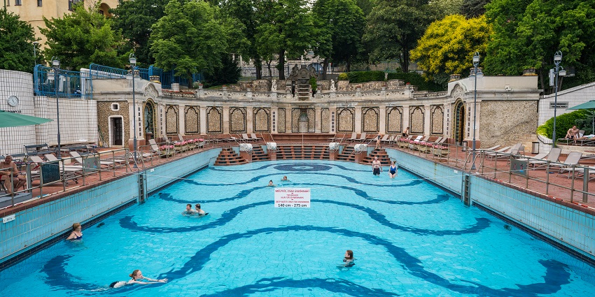 People relaxing in the thermal baths in Budapest, surrounded by ancient architecture.