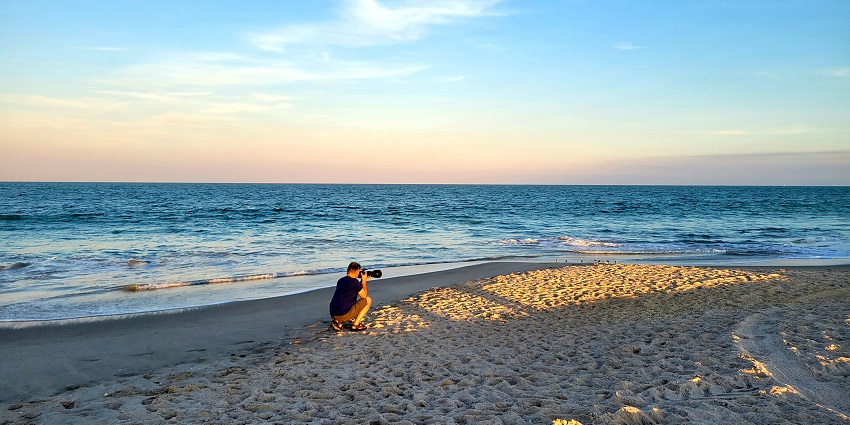 A photographer is capturing the morning vibrancy of a sunny and empty South Beach