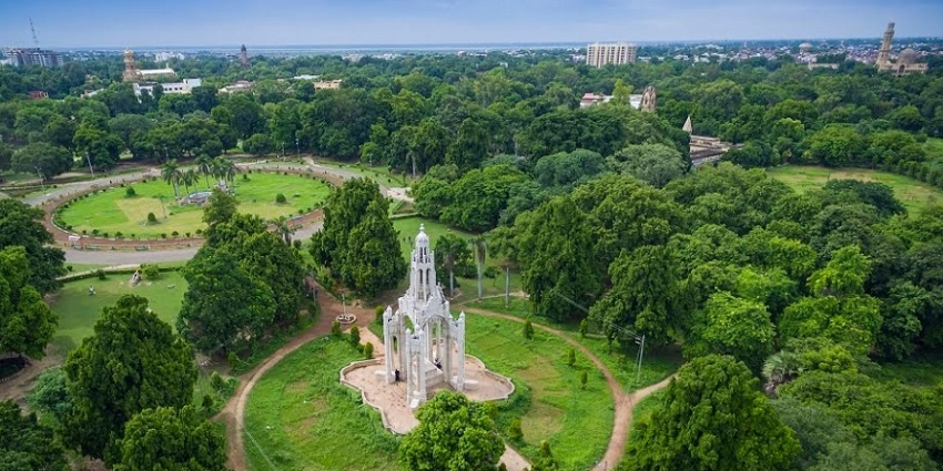 An image of Alfred Park with a Sidewalk inside and featuring seats and trees.