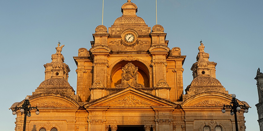 The entrance of St. John’s Co-Cathedral is closed on a sunny day with a clear sky.