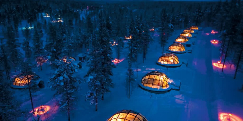 Igloo village in Saariselka with glass igloo stays in the snow-covered area with trees.