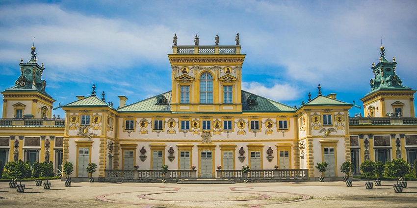 Image of Wilanow Palace with stunning architecture, lush green garden under clear blue sky