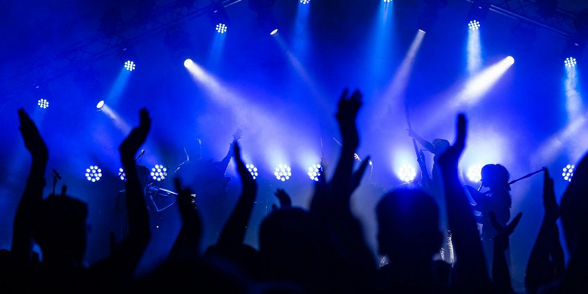 A crowded nightclub with people enjoying the energetic atmosphere, illuminated by dynamic, colorful lights.