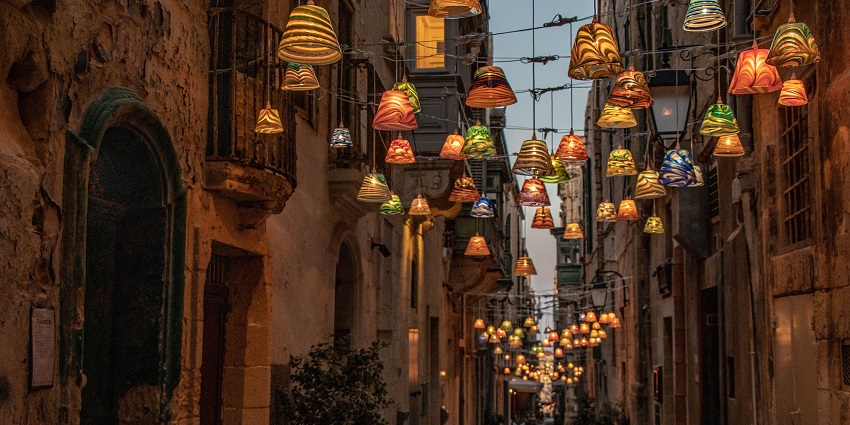 Strait Street with designer lamp lights hanging in lines with old building structure