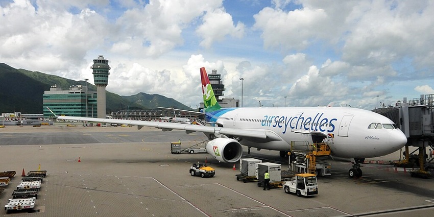 A view of the place that took off from the airport showing sea, airport towers and sky.