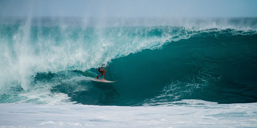 A picture of a guy surfing–one of the ideal things to do at Green Bowl Beach
