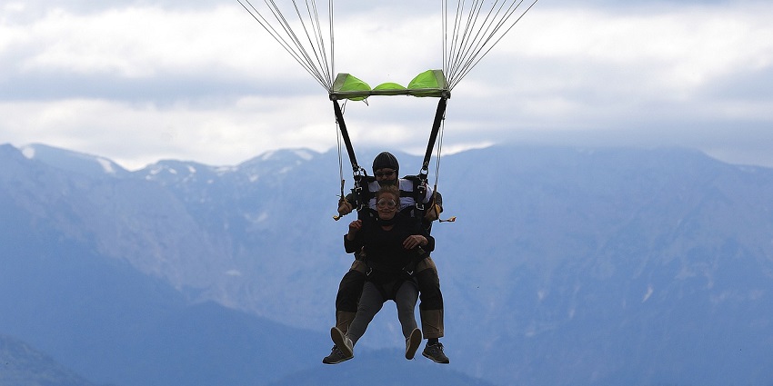 A picture of skydiving: Tandem jump with a parachute, soaring above Prague's skies.