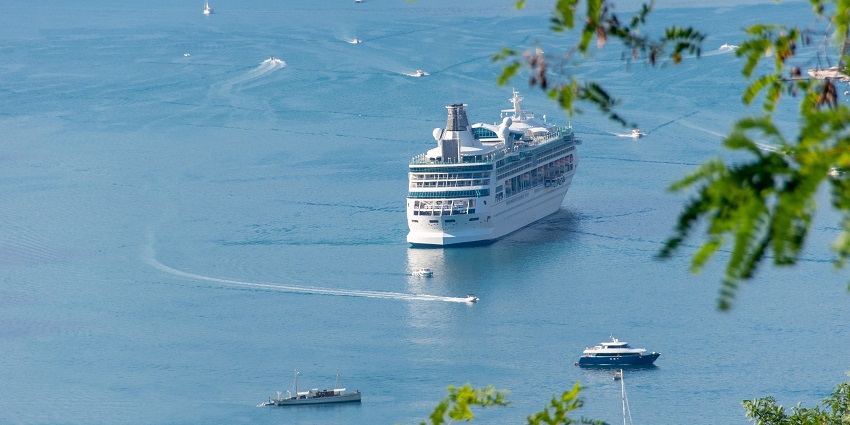 An image of Passengers on a ferry enjoying sea views, surrounded by calm water and distant cliffs.