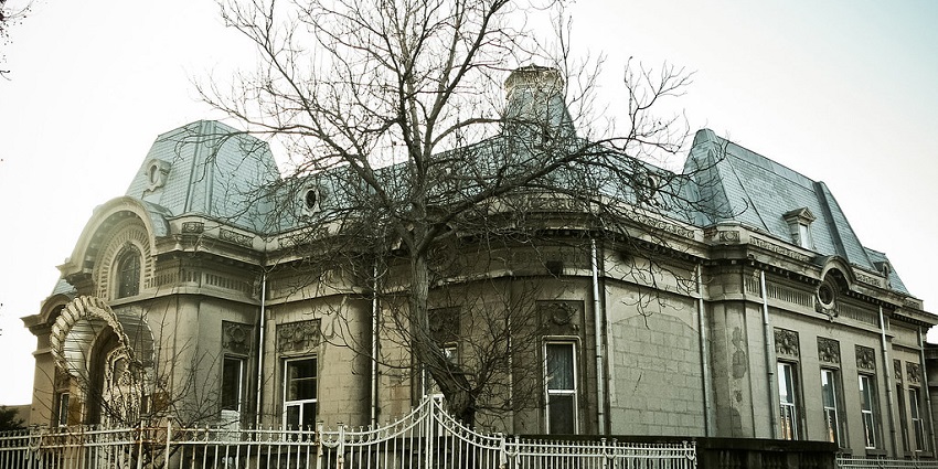 A haunted house wears a spooky look, with a dried tree enhancing the horror atmosphere.