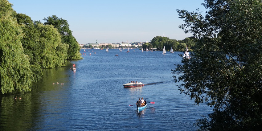 People riding boats on the Alster Lake of Hamburg with ducks, a spot for Valentine's Day in Germany.