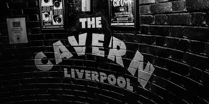 An image of The Cavern Club entrance in Liverpool with posters and images on walls.