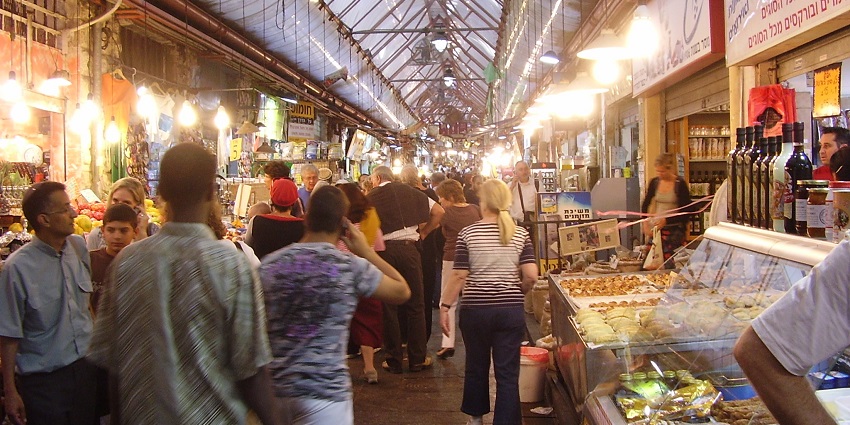 Bustling market filled with fresh produce and spices where tourists gather for a lively atmosphere.