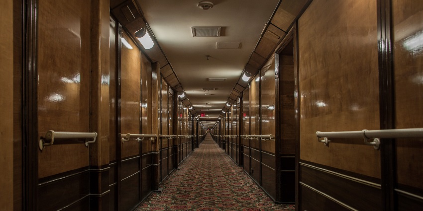 An image of a hallway of the iconic Queen Mary in Long Beach, California, known for its ghostly tales.