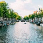 Image of water and building surrounded - An amazing view of the city of Amsterdam