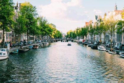 Image of water and building surrounded - An amazing view of the city of Amsterdam