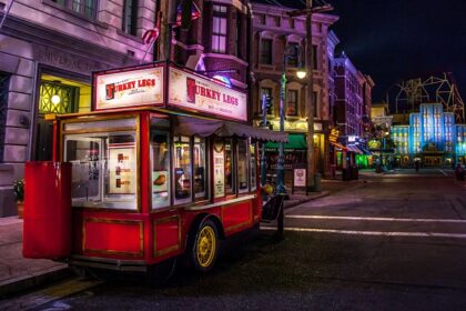 Vibrant street in Old town Orlando at night with a small food on wheels named turkey legs