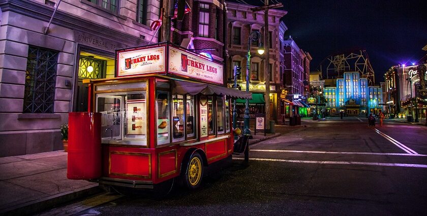 Vibrant street in Old town Orlando at night with a small food on wheels named turkey legs