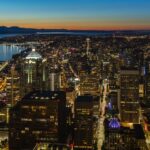 The cityscape of Seattle with tall buildings on one side and a water bay on another